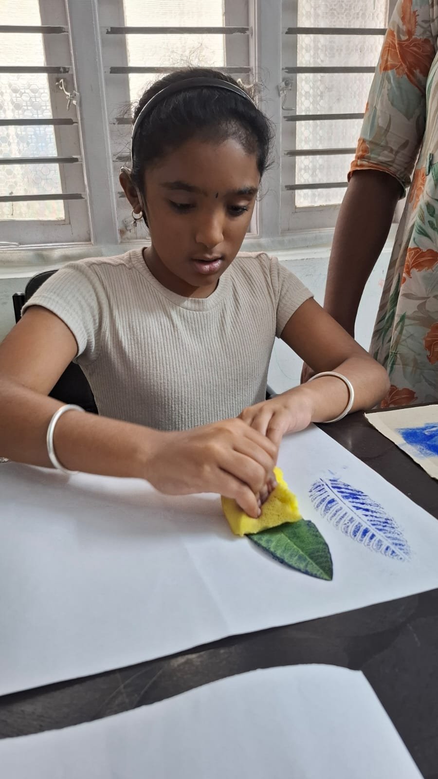 Learner creating a leaf print during a hands-on art activity